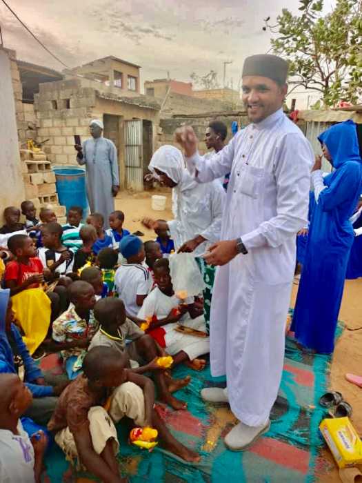 Imam Shaykh Safraz Bacchus, center engaged several African children during his 2024 trip to continue his humanitarian work. He distributed school supplies and food hampers.