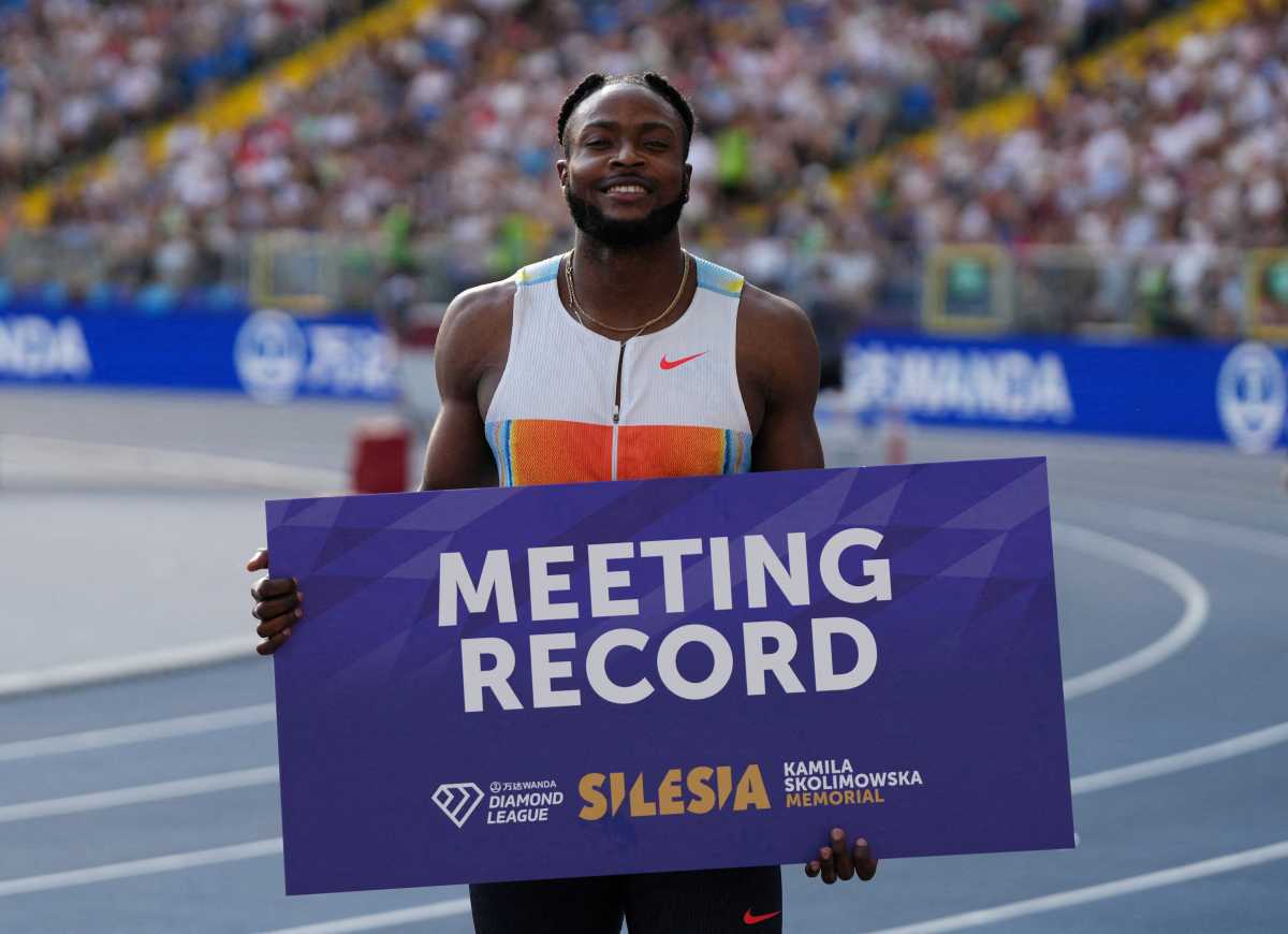 man racing holding sign about meeting record jamaica track runner