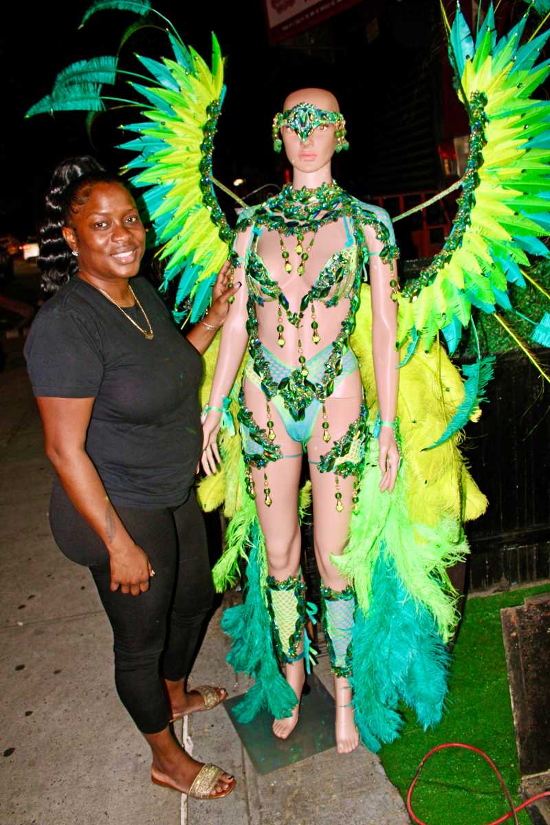 Maxine Magdalino, bandleader of SugaCandy Mas poses with a dazzling green embellished costume - Paradise - a section from the depiction - Genesis.