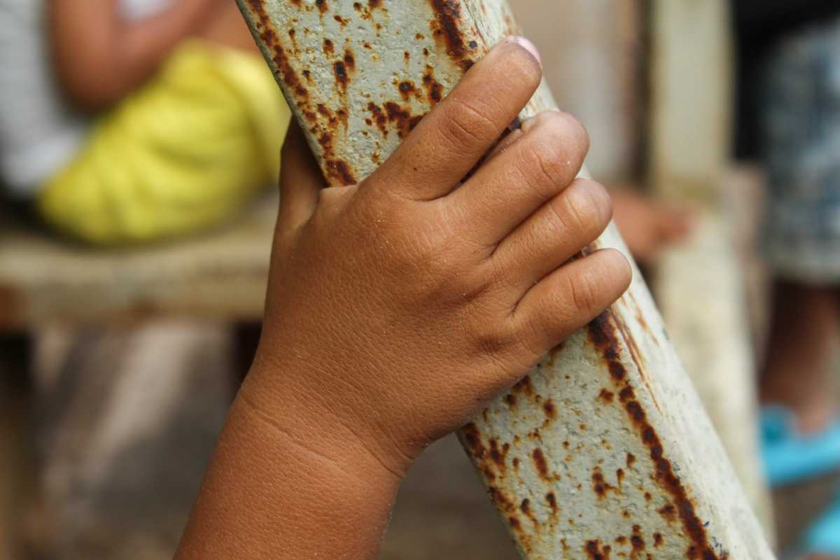 Close up of little boy's hand holding on to scrap metal