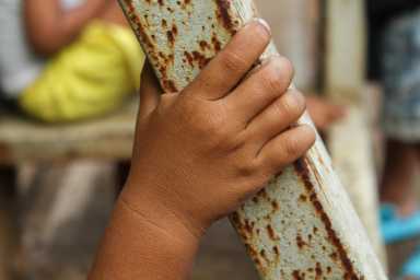 Close up of little boy's hand holding on to scrap metal