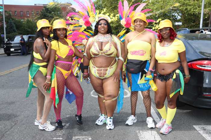 Felicia England, center, portrays Suga Candy Mas' "Forsithia", flanked by other Suga Candy masqueraders