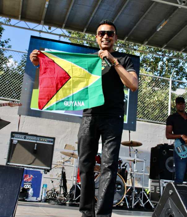 Chutney singer of popular Guyana Baboo, Terry Gajraj showed off the Golden Arrowhead flag, and got patrons on their feet to wave and dance, during the 25th GCA Folk Festival Funday on Aug. 31 at Old Boys High school grounds in Brooklyn.