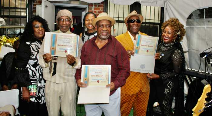 From left, President of the Guyana American Heritage Foundation, and Curator of the Musician Appreciation Awards, Lady Ira Lewis, Bass Guitarist, Drummer Colin Stewart, Lead Guitarist, Richard Schultz, and President of the Guyana American Heritage Foundation, with their Awards. Miss CARICOM, Monica Sanchez, far right, at the Musician Appreciation Awards, at the Waterfall Lounge, on Church Avenue, Brooklyn, on Sept. 14, 2025.