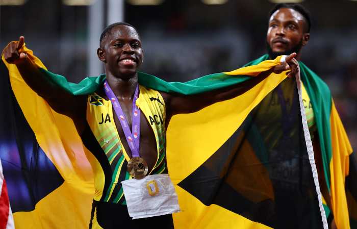 Jamaica's Oblique Seville celebrates with a gold medal and Jamaica flag after winning the Men's 100m Final at the World Athletics Championships at the Japan National Stadium, Tokyo, Japan on Sept. 14, 2025.