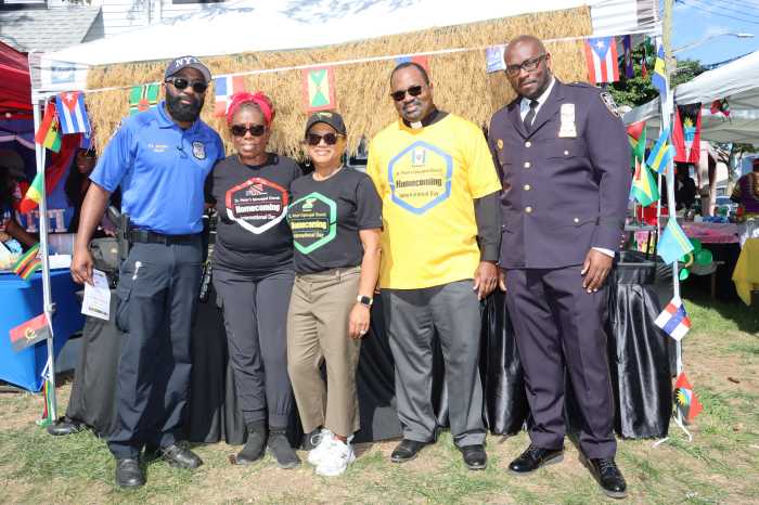 Haitian-born NYPD officers help to keep the peace at the Homecoming: Deputy Inspector of 116 Precinct Sony Beauvoir, right, with Community Affairs Officer, 116 Precinct Guy Joseph, left. Others in photo, from left, Event Coordinator Trinidadian Monica Carrington; Jamaican Seminarian at St. Peter's Episcopal Church Paul Kong-Sinclair; and Barbadian Rector at St. Peter's Episcopal Church the Rev. Dr. Steve Foster.