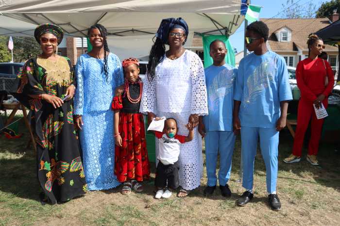 Nigerians stand in front of their tent.