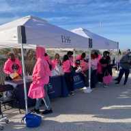 A group of attendees, at booths getting ready for the 8th Annual Trina Williams Far Rockaway Breast Cancer and Domestic Violence Awareness Walk, sponsored by various local organizations, including The Campaign Against Hunger (TCAH).