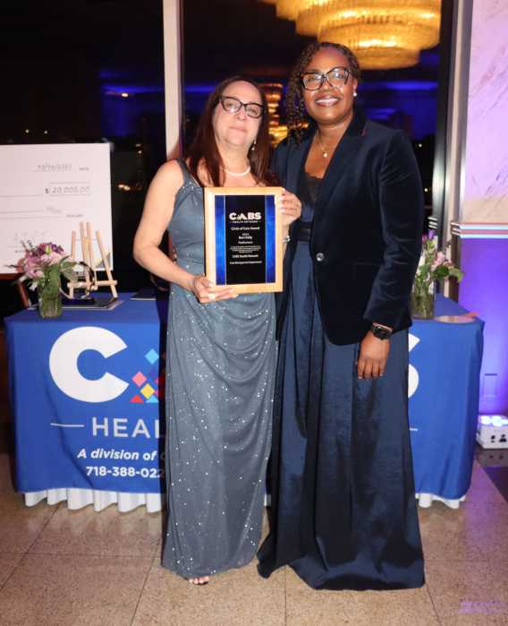 Ximora Inga, left, receives post-humous award from CABS' CEO Sherly Demosthenes-Atkinson, on behalf of Bob Kelly, the late CABS' associate director of care management.