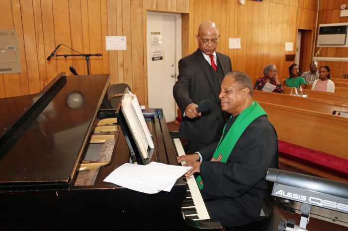 Rev. Lawrence Craig sings and plays the piano, with Shaphat Jack, president of FSUMC Men's Group, providing better audio through a microphone.