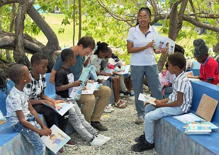 GraceKennedy Foundation Project Officer Jade-Ashley Carberry- Meikle engages with TV host Zay Harding (fourth from left) and children from the Rose Town community in Kingston during filming of The Visioneers With Zay Harding.