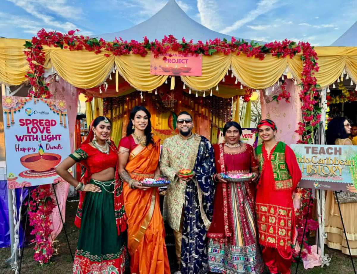 Mohamed Q. Amin, third from left, founder/president of the Caribbean Equality Project, surrounded by members, in front of their colorful ornate booth at the Annual Diwali Festival on Oct. 18, in Smokey Park, Queens.