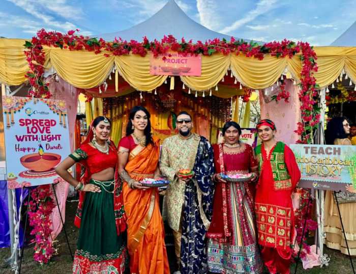 Mohamed Q. Amin, third from left, founder/president of the Caribbean Equality Project, surrounded by members, in front of their colorful ornate booth at the Annual Diwali Festival on Oct. 18, in Smokey Park, Queens.