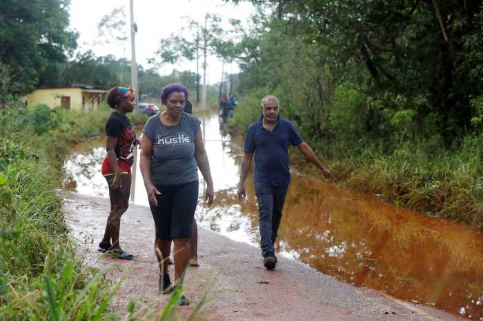 People walk on a flooded road, after Hurricane Melissa made landfall, in Prospect, Manchester, Jamaica, Oct. 29, 2025.