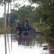 People sit on the roof of a vehicle riding on a flooded road, after Hurricane Melissa made landfall, in Prospect, Manchester, Jamaica, Oct. 29, 2025.