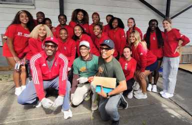 Track & Field Athletes of St. John's University in Queens, strike a pose on Saturday, Sept. 27 - "University Service Day" at the newly branded Community Food Pantry Inc. in Richmond Hill. The ladies and coaches volunteered, bagging and serving nutritious meals to hundreds of residents in two sessions. From left, stooping front, are Coach Desmond Robinson, and Board Members of Community Food Pantry, Roger Gary, and Tony Singh.