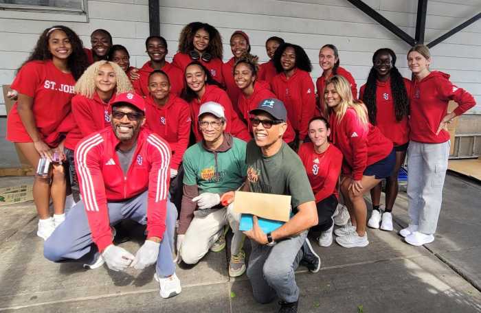 Track & Field Athletes of St. John's University in Queens, strike a pose on Saturday, Sept. 27 - "University Service Day" at the newly branded Community Food Pantry Inc. in Richmond Hill. The ladies and coaches volunteered, bagging and serving nutritious meals to hundreds of residents in two sessions. From left, stooping front, are Coach Desmond Robinson, and Board Members of Community Food Pantry, Roger Gary, and Tony Singh.