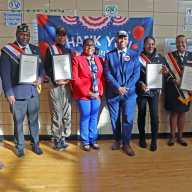 Veteran honorees display proclamation with New York State Assembly Member Stefani L. Zinerman, center, and NYC Department of Veterans' Services Commissioner James W. Hendon, to her immediate left.
