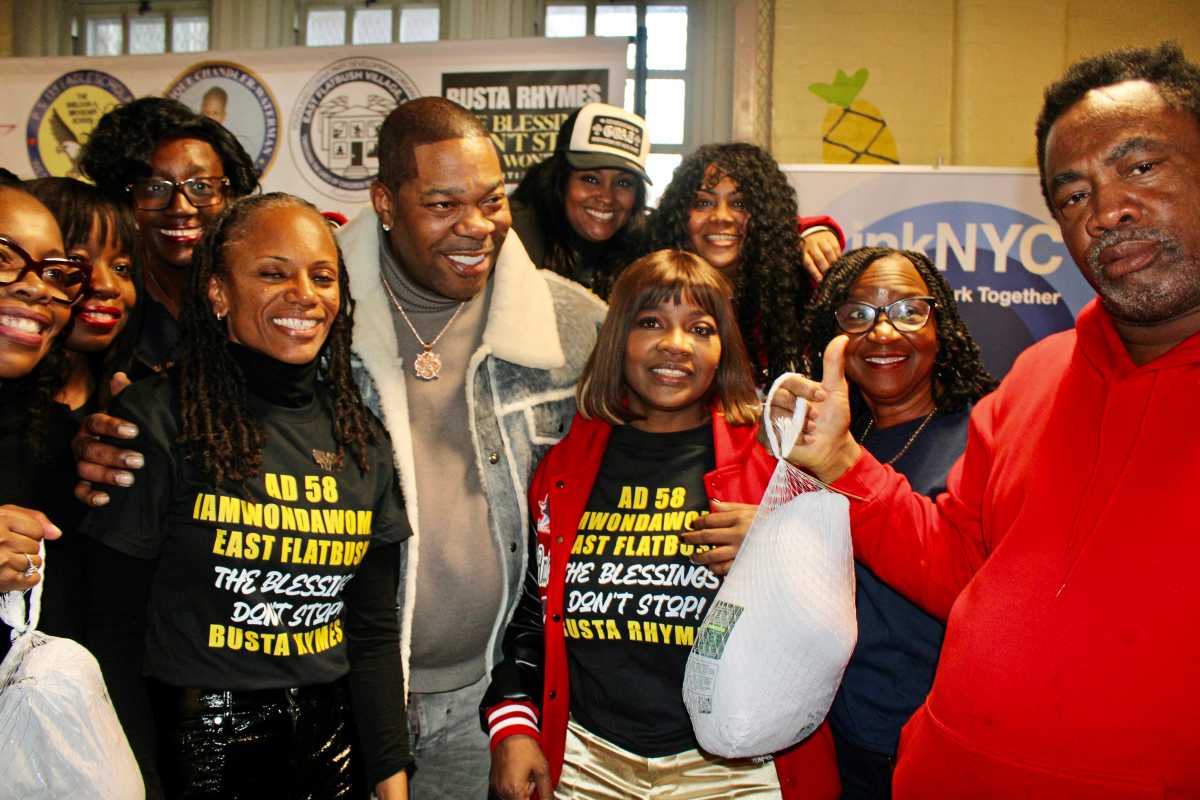From left, Council Member Rita Joseph, PS 135 Superintendent Celeste Terry, Principal of PS 135 Mrs. Mcrae, front, Assembly Member Monique Chandler-Waterman, Busta Rhymes, Dr. Meda Leacock, and others helping the Blessings Don't Stop singer distribute turkeys on Nov.22, 2025 at PS 135.