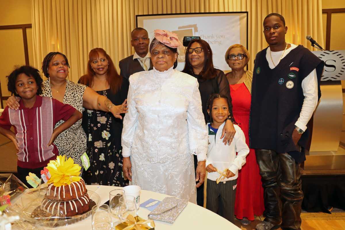 Pastor Neithe E. Soleyn, center, with family members flank her birthday cake.