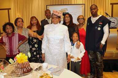 Pastor Neithe E. Soleyn, center, with family members flank her birthday cake.