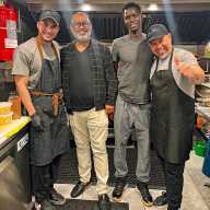 Sooroojballie stands with his chef and kitchen staff, the team behind Déjà Brew Café’s flavorful fusion dishes that celebrate Caribbean, American, and Latin influences.