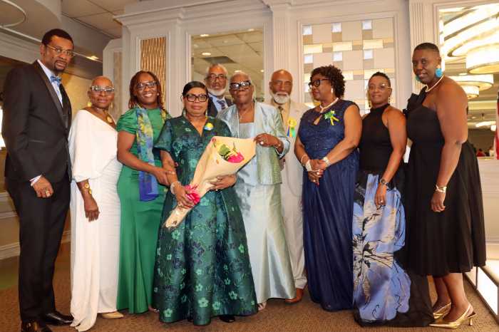 Laverne McDowald-Thompson, vice president of the Brooklyn-based Council of St. Vincent and the Grenadines Organizations, U.S.A., Inc. (COSAGO) and chairperson of COSAGO's Fundraising Committee, center, gets bouquet of flowers for her hard work, flanked by Guest Speaker Sherill-Ann Mason-Haywood, right; Counsel General to the US Rondy "Luta" McIntosh, left; McIntosh's wife, Semone, second from right; and COSAGO executive members.