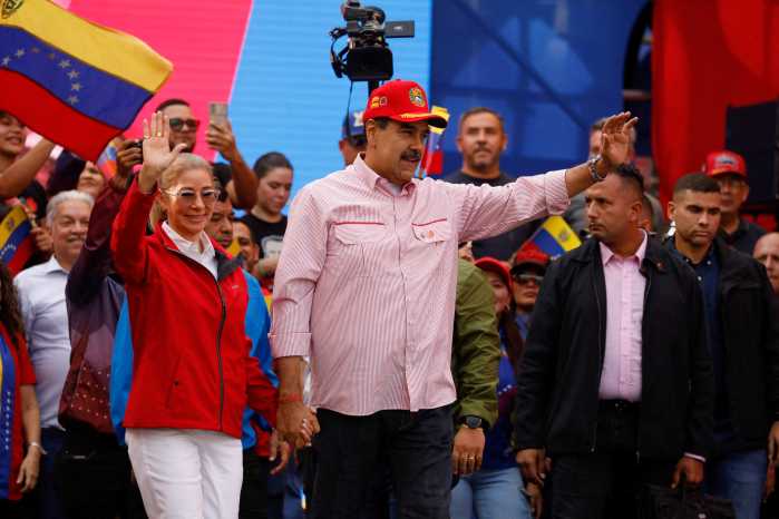 Venezuela's President Nicolas Maduro waves while holding the hand of his wife Cilia Flores during a ceremony to swear in new community-based organizations, as U.S. President Donald Trump’s administration ramps up pressure on Maduro’s government, in Caracas, Venezuela, December 1, 2025.