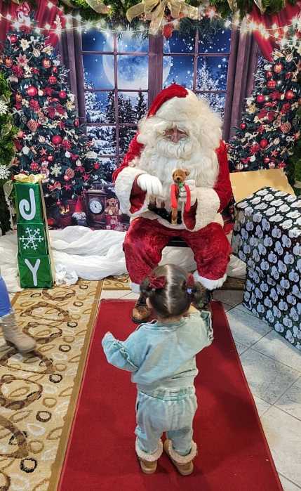 A child receives a toy bear from Santa Claus.