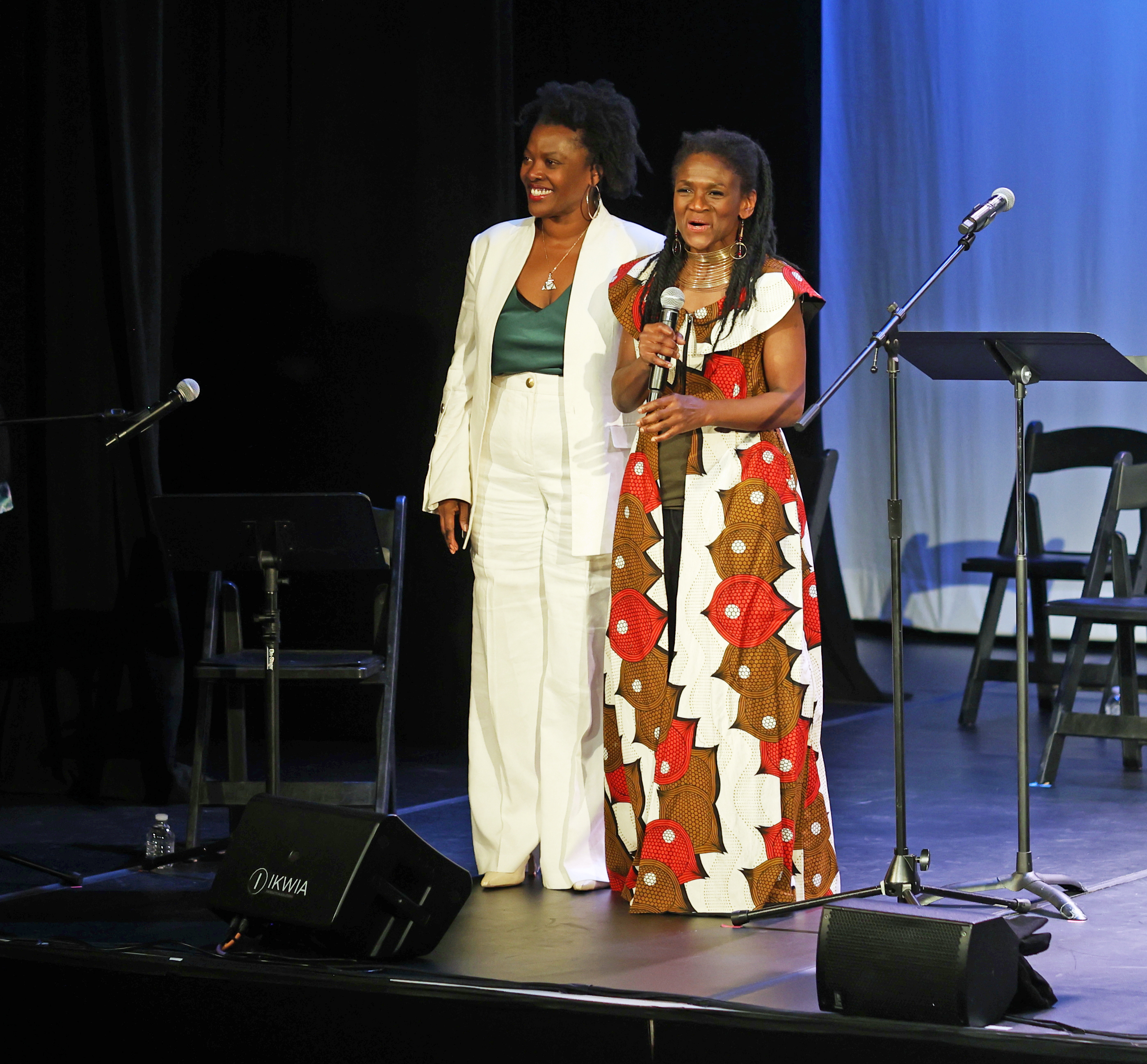 Curators Heather Simms and Patrice Johnson Chevannes standing next to each other on stage at the Billie Holiday Theater for the celebration on Dec. 13, 2025.