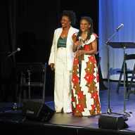 Curators Heather Simms and Patrice Johnson Chevannes standing next to each other on stage at the Billie Holiday Theater for the celebration on Dec. 13, 2025.