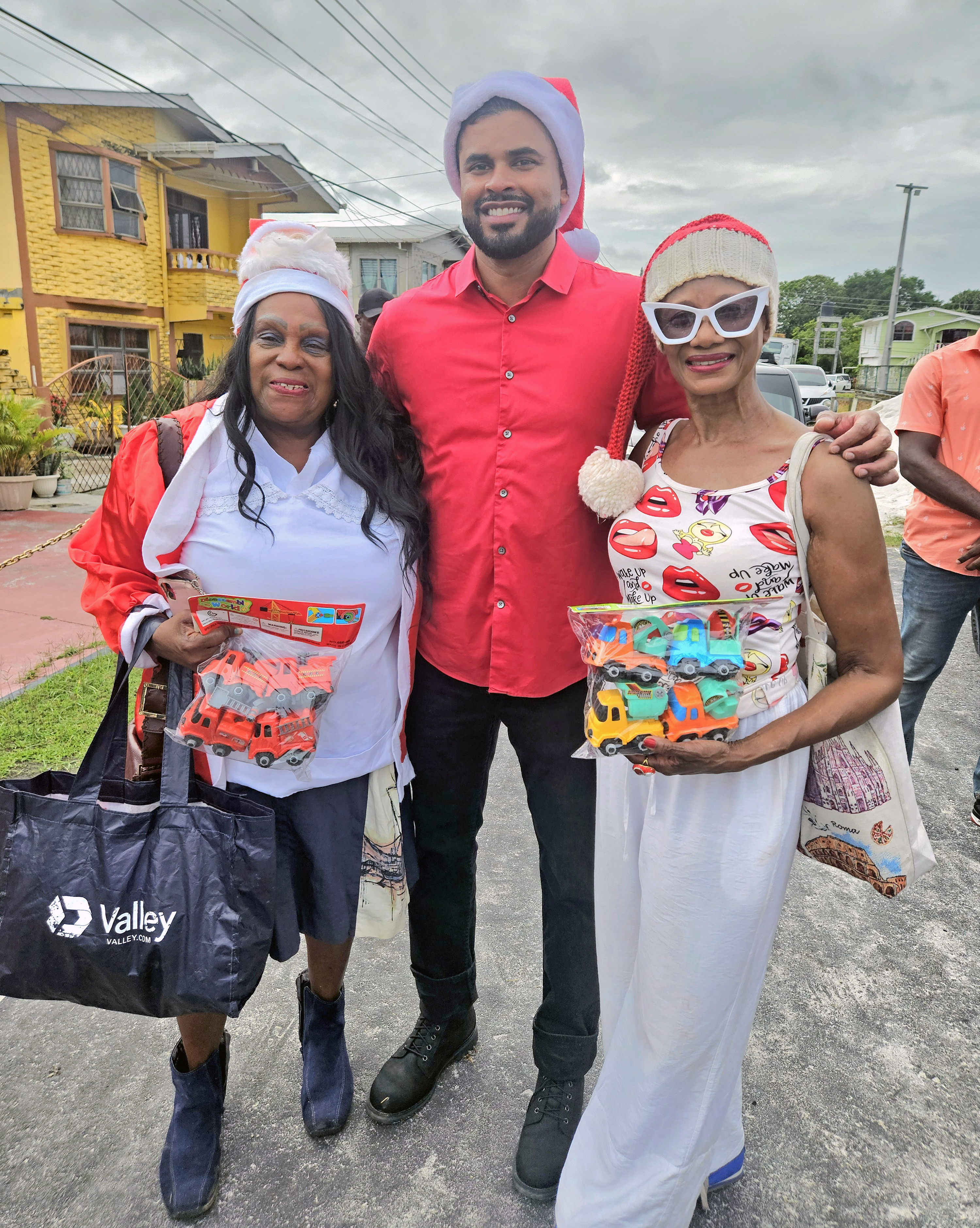 President of the Guyana America Heritage Foundation USA, Lady Ira Lewis, Minister of Culture, Youth and Sports Charles S. Ramson, and Caribbean Life's contributor Tangerine Clarke, during a Dec. 21, toy giveaway in Agricola Village, on the East Coast of Demerara, Guyana.