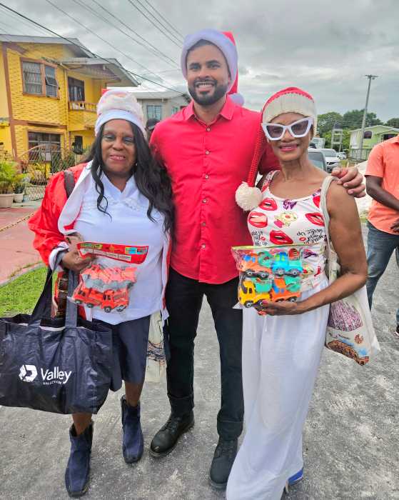 President of the Guyana America Heritage Foundation USA, Lady Ira Lewis, Minister of Culture, Youth and Sports Charles S. Ramson, and Caribbean Life's contributor Tangerine Clarke, during a Dec. 21, toy giveaway in Agricola Village, on the East Coast of Demerara, Guyana.