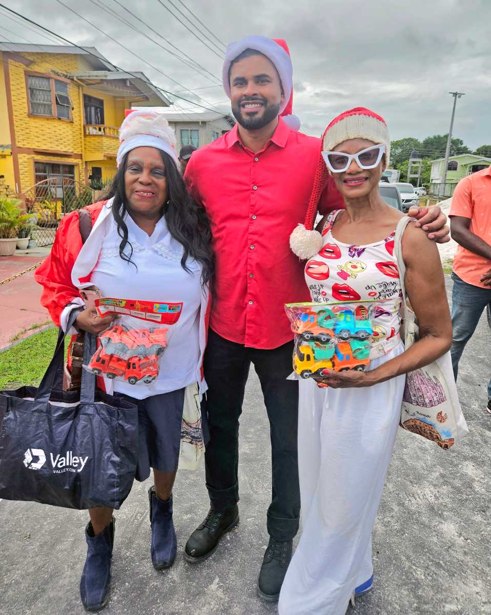 President of the Guyana America Heritage Foundation USA, Lady Ira Lewis, Minister of Culture, Youth and Sports Charles S. Ramson, and Caribbean Life's contributor Tangerine Clarke, during a Dec. 21, toy giveaway in Agricola Village, on the East Coast of Demerara, Guyana.