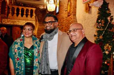 Guyana Consulate Staffer, Karen Pesaud, President Mohamed Irfaan Ali, and Sudesh Persaud, (husband and wife) pose with the head-of-state's at the International Center for Democracy Christmas during a layover in NYC, on his way to Guyana, on Dec. 13, 2025.