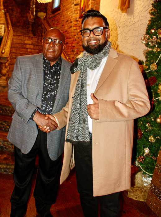 Consul General to New York Ambassador Michael E. Brotherson (left) greets President Mohamed Irfaan Ali with a grand handshake at the International Center of Democracy (ICD) Christmas Social on Dec. 13 in Queens. The head-of-state used a layover to meet with nationals.