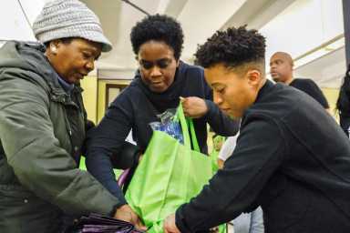 Crystal Hudson, right, assists with a Thanksgiving bag.