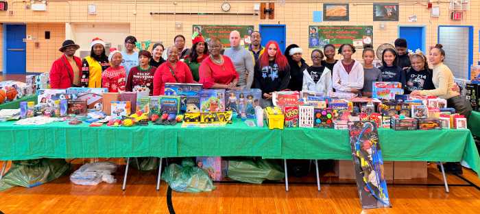 Toys in forefront with Sen. Roxanne Persaud, center, flanked by children and staff.