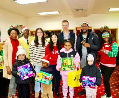 From left, Immigration Attorney Melnia Cordis, host of the Reset Talk Show, JR Giddings, family, Maria Weigand, Mrs. Sharon Weigand, Audiologist, SUNY Downstate Hospital, John Weigand, Public Advocate Jumaane Willliams, volunteer Claire Patterson-Monah, and children with their toys, at the 2nd Annual toy giveaway, hosted by the Reset Talk Show, at Reflections Church, on Dec. 13, 2025.