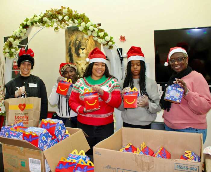 Santa's helpers showcase meals from McDonald's, who partnered with the Reset Talk Show for the group's 2nd Annual Toy Giveaway to put smiles on the faces of many Brooklyn children. The festive event was held at Reflections Church on Utica Avenue, headed by Pastor Louis Straker Jr. on Dec. 13, 2025.