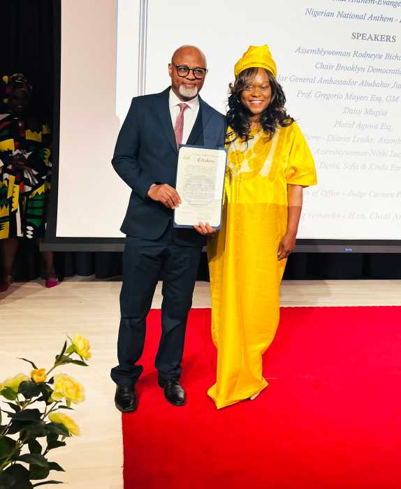 Judge Chidi Eze holding a citation presented to him by Assembly Member Rodneyse Bichotte Hermelyn during his induction.