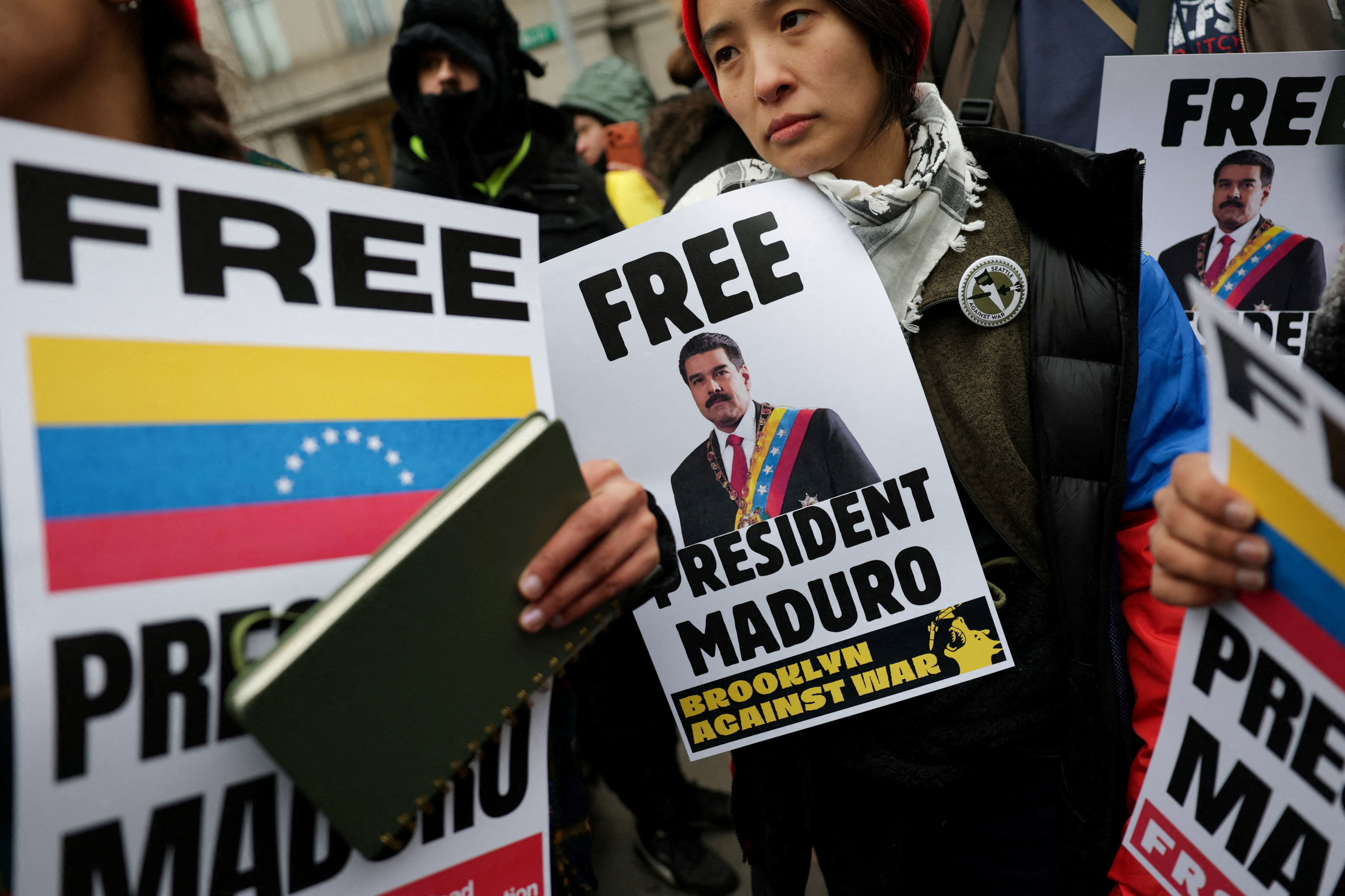 Demonstrators hold placards during a protest against U.S. strikes against Venezuela and the capture of Venezuelan President Nicolas Maduro, outside the Daniel Patrick Moynihan United States Courthouse as he makes an initial appearance to face U.S. federal charges including narco-terrorism, conspiracy, drug trafficking, money laundering and others in New York City, U.S., January 5, 2026.