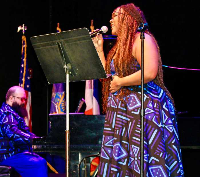 Vocalist Aiysama Lennard, of Panamanian heritage, foreground, sang the Black National Anthem - Lift Every Voice and Sing, accompanied by Nathan Ferraz, on piano. The Aaron Copland School of Music Graduate Students performed at the Annual MLK Day commemoration on Jan. 18, in the Goldstein Theatre, at CUNY Queens College in Flushing.
