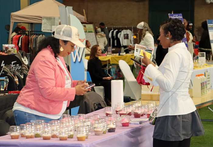 Panamanian-born, Brooklyn resident Zeneth Yesssenia Buzzela, founder of Queen YesseniaB. Sweet & Savory Cupcakes, with a customer at the exposition at Major R. Owens Health & Wellness Community Center in Brooklyn.