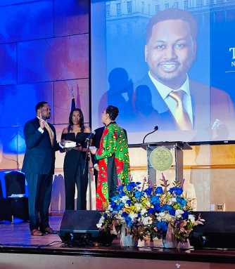 Former Council Speaker Adrienne Adams administers the oath to Council Member Tyrell Hankerson as his mother holds the Bible during the swearing-in ceremony.