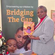 Caren Charles De Freitas holding her first children's book, "Girl in a Pretty Dress."