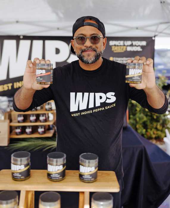Bottles of WIPS red and yellow Scotch bonnet peppa sauces are displayed during a Lunar New Year event hosted by Lucky Cat Mini Mart in Central Florida, highlighting the brand’s growing presence at community and cultural gatherings.