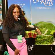 Chimarie Morillo St. Kitts & Nevis Tourism Authority Midwestern Sales Representative in the United States, poses for a picture against the backdrop of pristine landscapes of St. Kitts during the recent 2026 New York Travel & Adventure Show at the Jacob Javits Center.