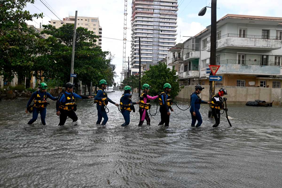 Rescue workers walk on a flooded street in Havana, Cuba Feb. 1, 2026.