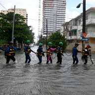 Rescue workers walk on a flooded street in Havana, Cuba Feb. 1, 2026.
